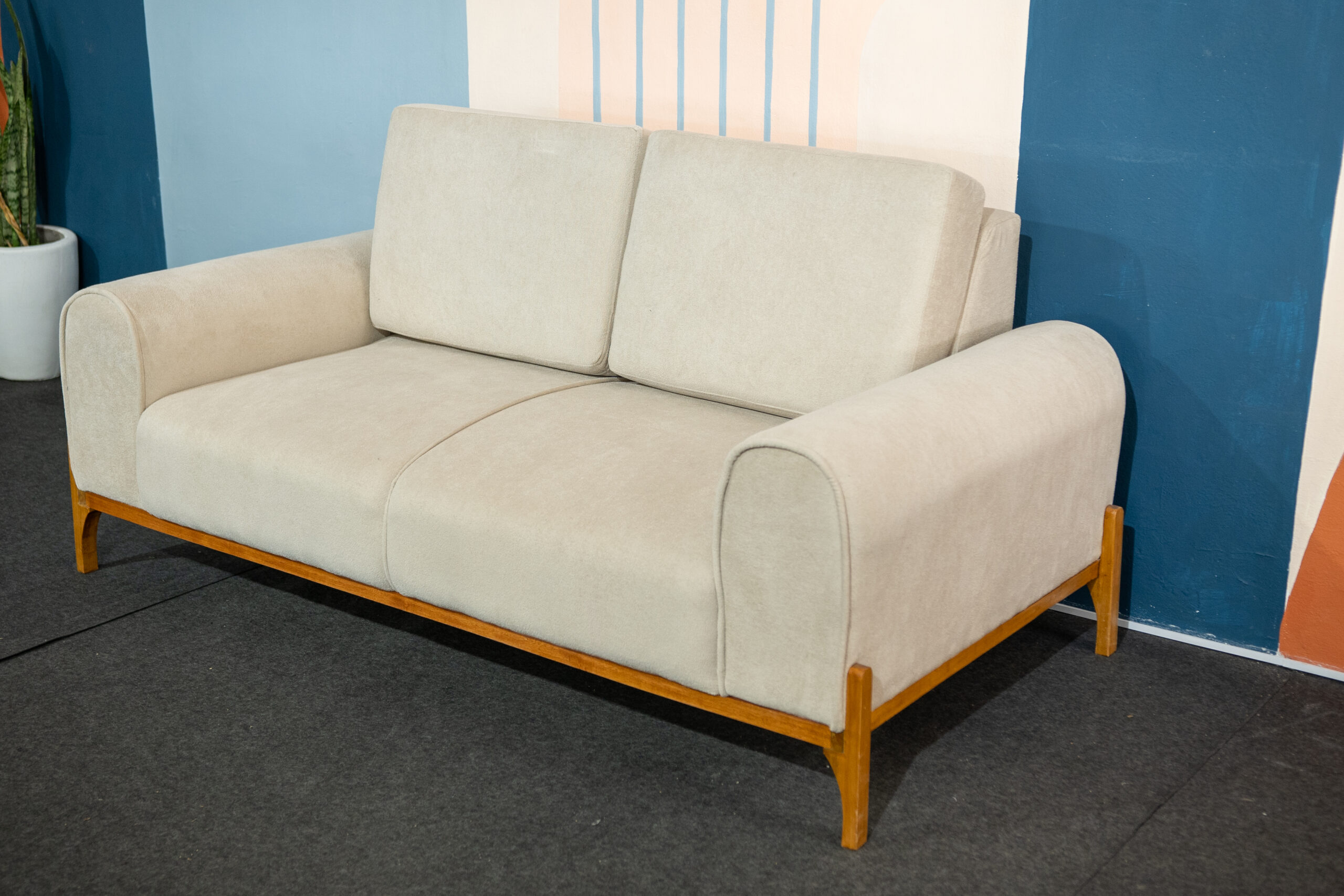 Sofá Vinti — elegancia, diseño y calidez natural. El Sofá Vinti combina líneas suaves con una estructura de madera a la vista que resalta su diseño artesanal y contemporáneo. Su base y patas en madera lustrada aportan un toque cálido y sofisticado, mientras que las formas redondeadas y las terminaciones finas reflejan una confección de alta calidad.