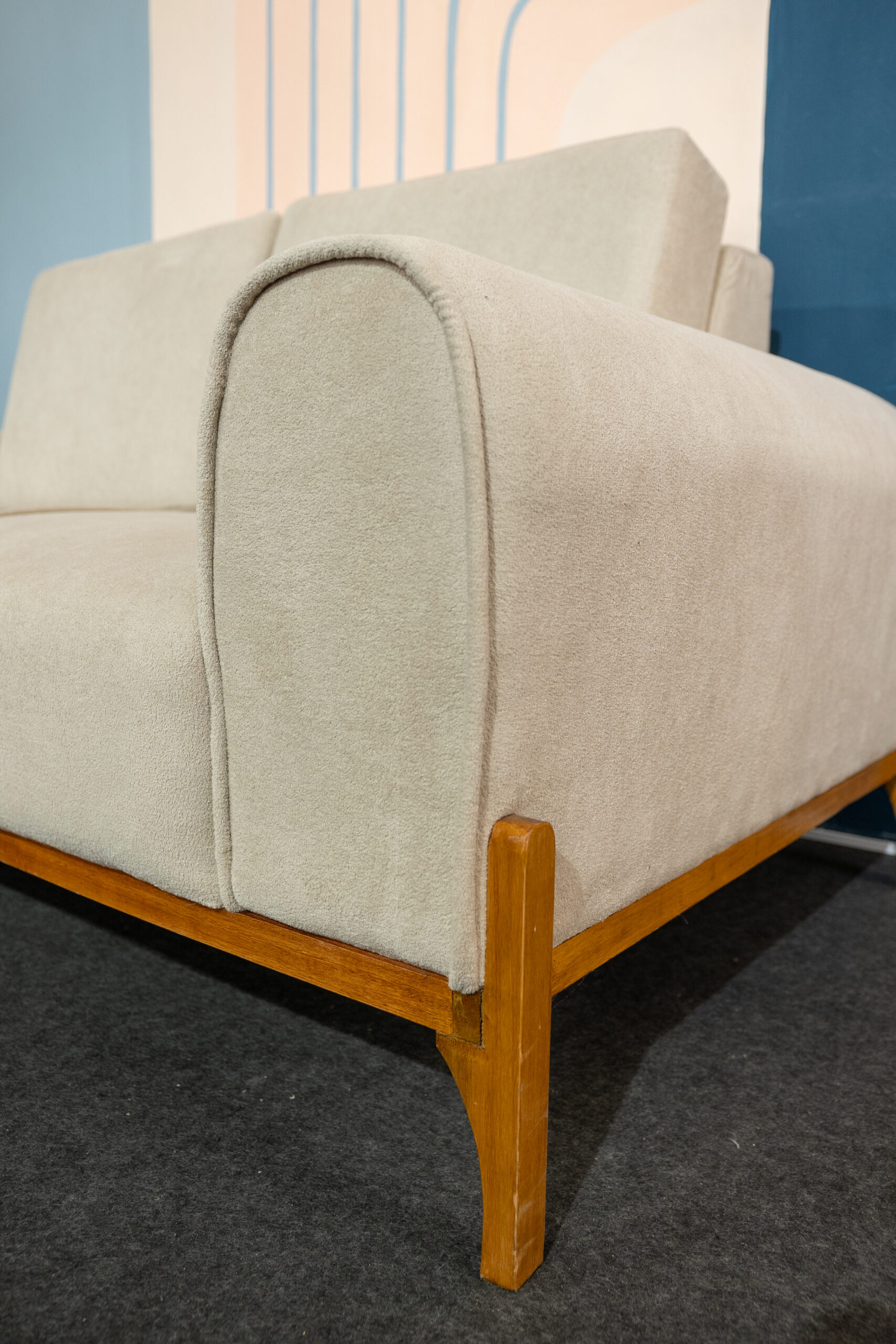 Sofá Vinti — elegancia, diseño y calidez natural. El Sofá Vinti combina líneas suaves con una estructura de madera a la vista que resalta su diseño artesanal y contemporáneo. Su base y patas en madera lustrada aportan un toque cálido y sofisticado, mientras que las formas redondeadas y las terminaciones finas reflejan una confección de alta calidad.